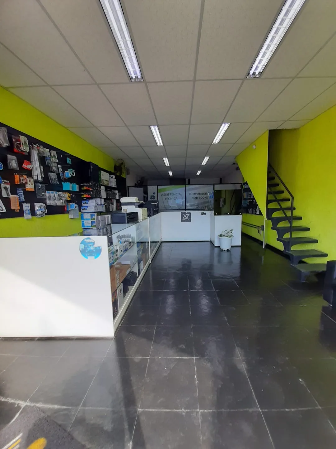 Interior da loja Vista Informática em Itaquaquecetuba, balcão de atendimento e parede de produtos