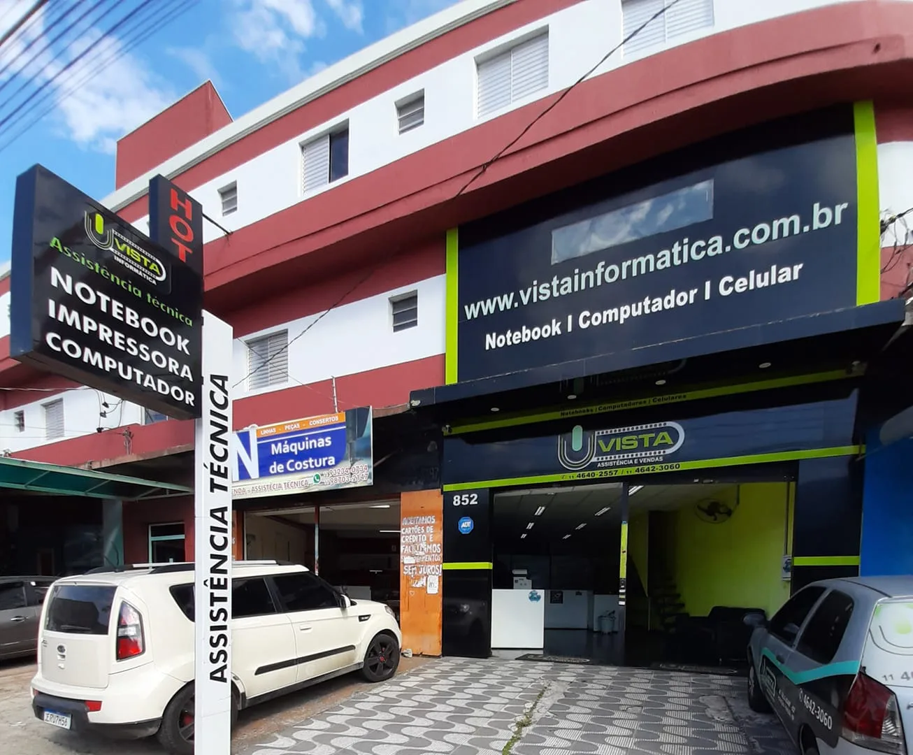 Fachada externa da Vista Informática com painel de assistência técnica de notebook, impressora e computador em Itaquaquecetuba