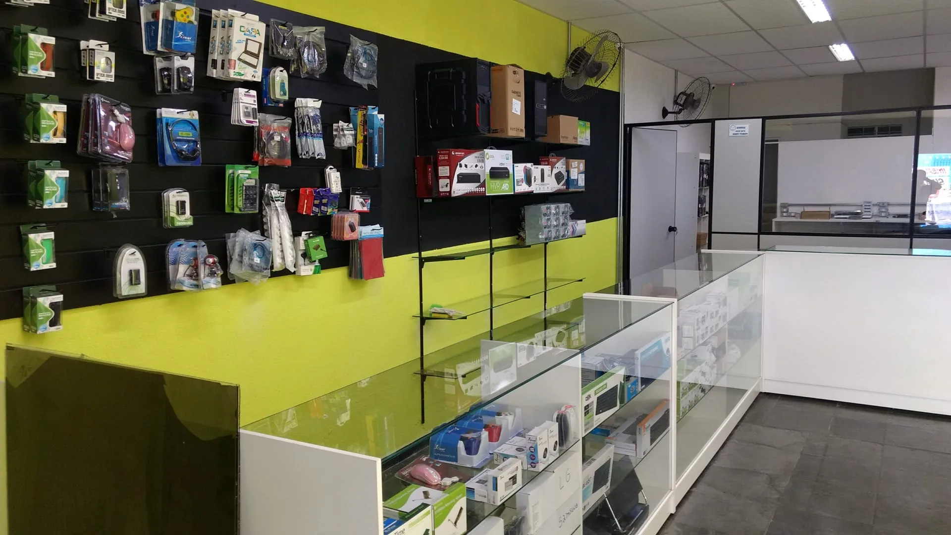 Interior da loja Vista Informática com parede de acessórios, cabos e periféricos em Itaquaquecetuba
